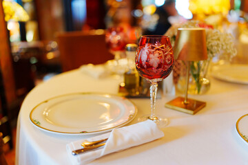 A small round table served with cutlery and a bouquet of flowers