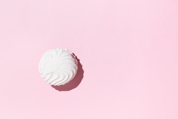 Soft white vanilla zephyr on light pink table. Pastel color. Banner with empty space for the text