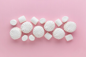 White marshmallows and zephyr on light pastel pink table. Banner with empty space for the text