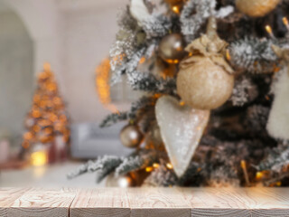 Wooden table near beautifully decorated Christmas tree. Space for design