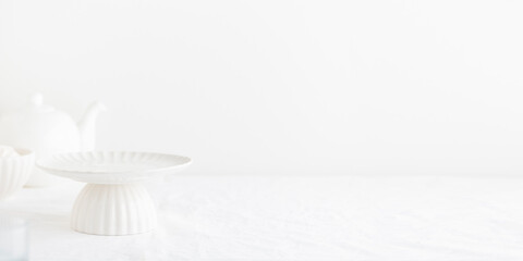 Fototapeta na wymiar Empty tableware - white plate cakestand on white table as a background for a dessert