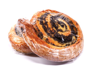 Two buns with poppy seeds wrapped in film isolated on a white background.