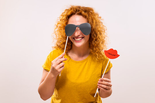 Happy ginger woman is having fun with party props.