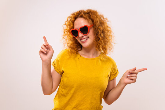 Image of happy ginger woman with red heart shaped sunglasses.