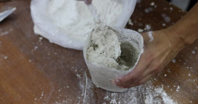 Adhesive cement mixture and gypsum are mixed for stucco on wall. 