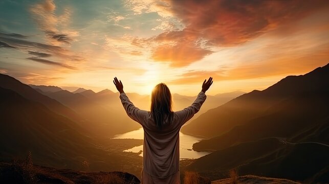 Silhouette of a woman praying outside at beautiful landscape at the top of the mountain, Copy space of man rise hand up on top of mountain and sunset sky abstract background
