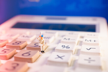 Miniature people, man raise one's hand sitting on white calculator using as business concept