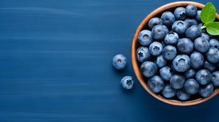 Flat lay of fresh organic juicy blueberries in a bowl on blue background, top view, copy space,Generated Ai