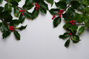 Holly leaves red berry frame border on white background. Christmas decoration. Holiday symbol....