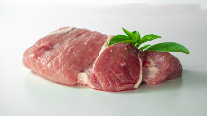 Pork with basil on a white background