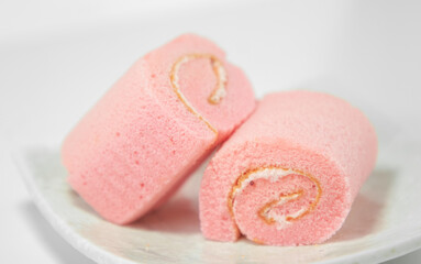 Strawberry roll cake on white background. Rose strawberry cake placed on a plate