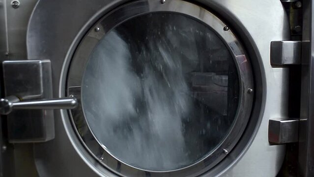 Rinsing washing machine drum with water. Professional dry cleaning of clothes