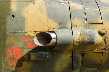Details of the fuselage of an old aircraft. Old camouflage surface with exfoliated paint and rivets on a military aircraft.