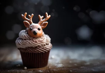 Selbstklebende Fototapeten Cupcake with chocolate reindeer with antlers decoration. Winter, seasonal muffin with deer face in sugar or chocolate. Festive food, treat for holiday celebration. © Caphira Lescante