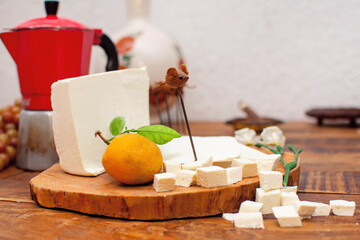 Toma de una tabla de madera con queso fresco partido en cubos y a la mitad exquisito manjar 