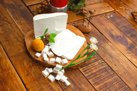 Tabla de madera con queso fresco y blanco cortado en cubos listo para degustar l&aacute;cteos exquisitos 