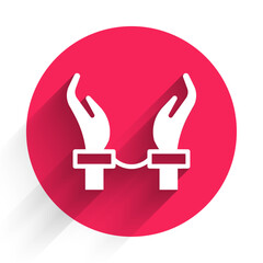 White Handcuffs on hands of criminal man icon isolated with long shadow. Arrested man in handcuffs. A crime, arrest, business and corruption concept. Red circle button. Vector