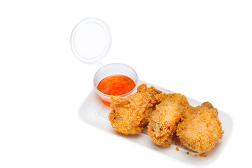 Vietnamese cuisine and food, breaded fried chicken wings with sauce on a plate, on a white isolated background