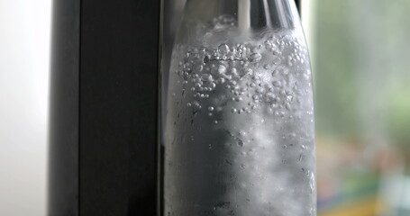 Adding sprinkling water into bottle, close-up of refreshing beverage, sprinkle water machine