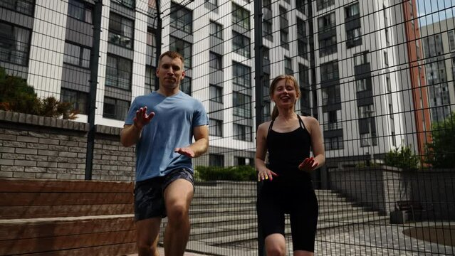 A man and a woman are training on a sports basketball court. Outdoor sports.