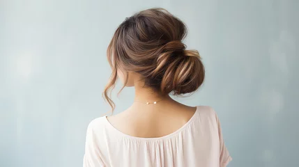 Tuinposter Messy dreamy low bun hairstyle for woman. Female hairstyle free bun, copy space. © SnowElf