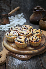 Plum muffins, cezve and cup of coffee, powdered sugar dressing