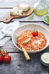 Italian cuisine. Plate of tomato risotto, olive oil, basil and cherry tomatoes - 668701910