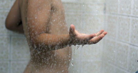 Droplets flowing splashing into child hand while bathing during bath routine, kid washing body in dreamy scene