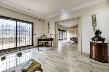 Large bedroom with double bed, suite with vintage-style wooden desk, large window with access to terrace and mirror mural behind the headboard of the bed