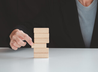 Hand arranging wood block stacking on top with white background. Business concept for growth success process	