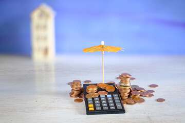 Wealth management, assest mangement concept with claculator,money and wooden house,focus on foreground,free copy space