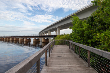 Boardwalk along a river under a bridge in Stuart, Florida