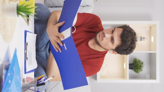 Vertical video of Clumsy man drops pen while at work desk.