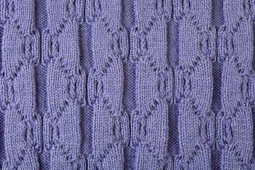 Knitted lilac abstract background. Large knitted fabric with a pattern. Close-up of a knitted blanket. Copy space