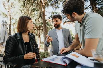 A business team discusses sales strategy over coffee in a downtown cafe. They focus on business growth, innovation, and sustainable expansion in the city.