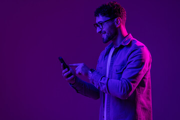 Man with phone use smartphone online, video call and selfies on mixed neon light