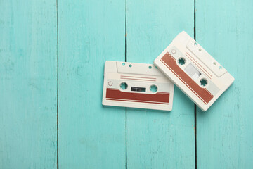 Retro 80s audio cassettes on blue wooden boards. Top view