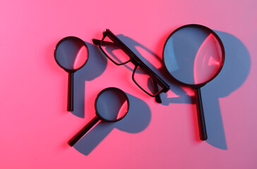 Magnifiers and eyeglasses in blue pink neon light