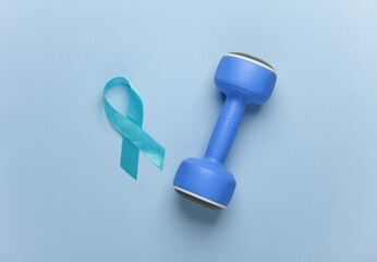 Blue ribbon symbolizing support of men and dumbbell on blue background. Blue november prostate cancer awareness month. International Mens Health Day. Flat lay