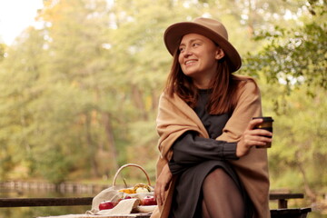 picnic by the lake, young woman smiling in a hat