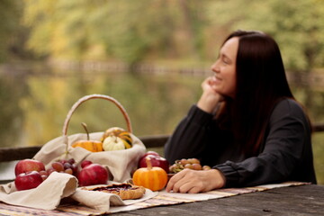 picnic by the lake, young woman, fruits, pie and pumpkins on the table