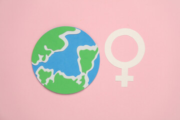 World Women's Day. Feminism. Female gender symbol and globe on pink background