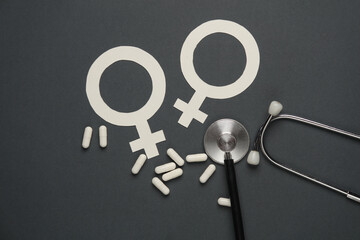Female gender symbols with pills and stethoscope on dark background © splitov27