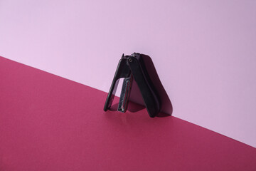 Stapler on pink background. Creative layout