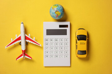 Toy taxi car model with globe, air plane and calculator on yellow background. Travel cost concept....