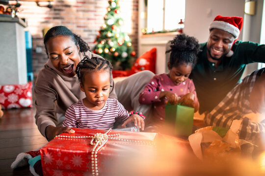 Young family opening presents during the Christmas holidays at home