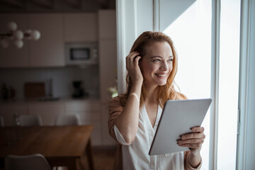 Young woman using her tablet in the living room at home
