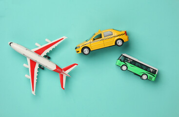 Toy taxi car model with bus and air plane on blue background. Travel concept. Top view