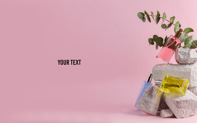 Perfume bottles on stone with eucalyptus branch. Natural cosmetics, beauty concept. Modern still...