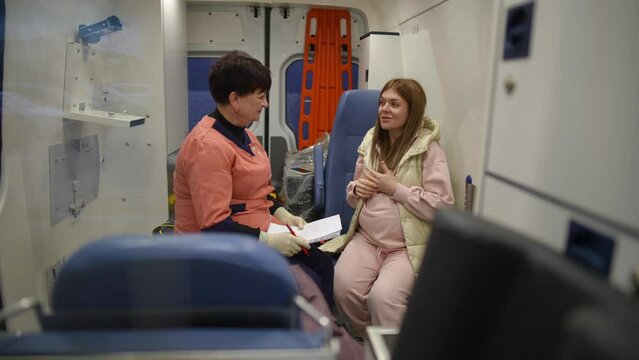 Pregnant girl complaining to ambulance paramedic about headache